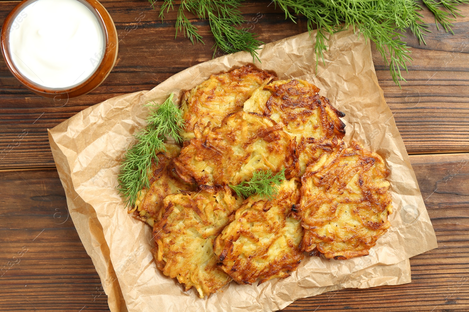 Photo of Delicious potato pancakes served on wooden table, flat lay