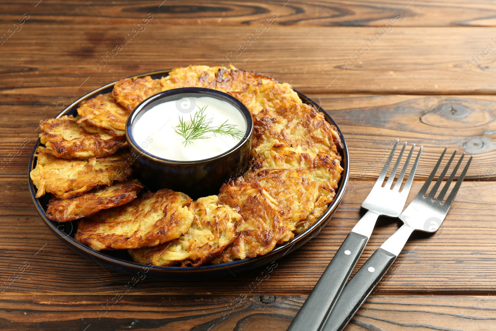 Photo of Delicious potato pancakes served on wooden table