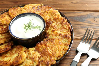 Photo of Delicious potato pancakes served on wooden table, closeup