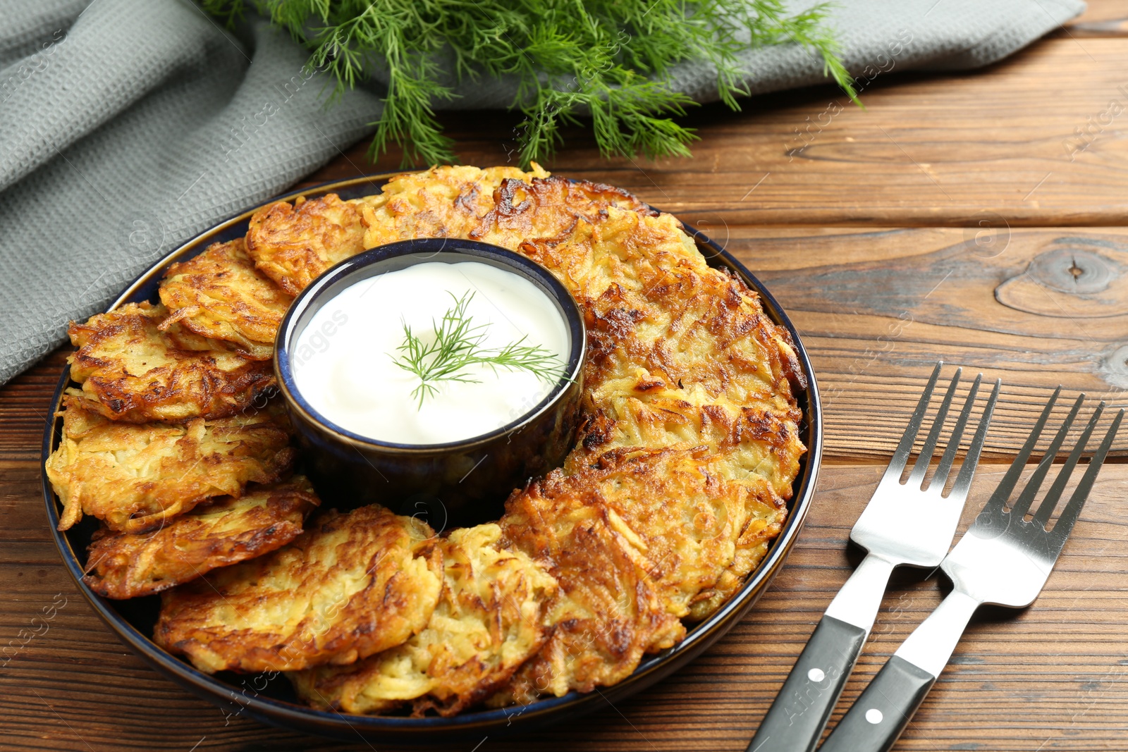 Photo of Delicious potato pancakes served on wooden table