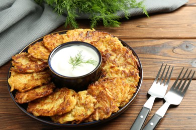 Photo of Delicious potato pancakes served on wooden table