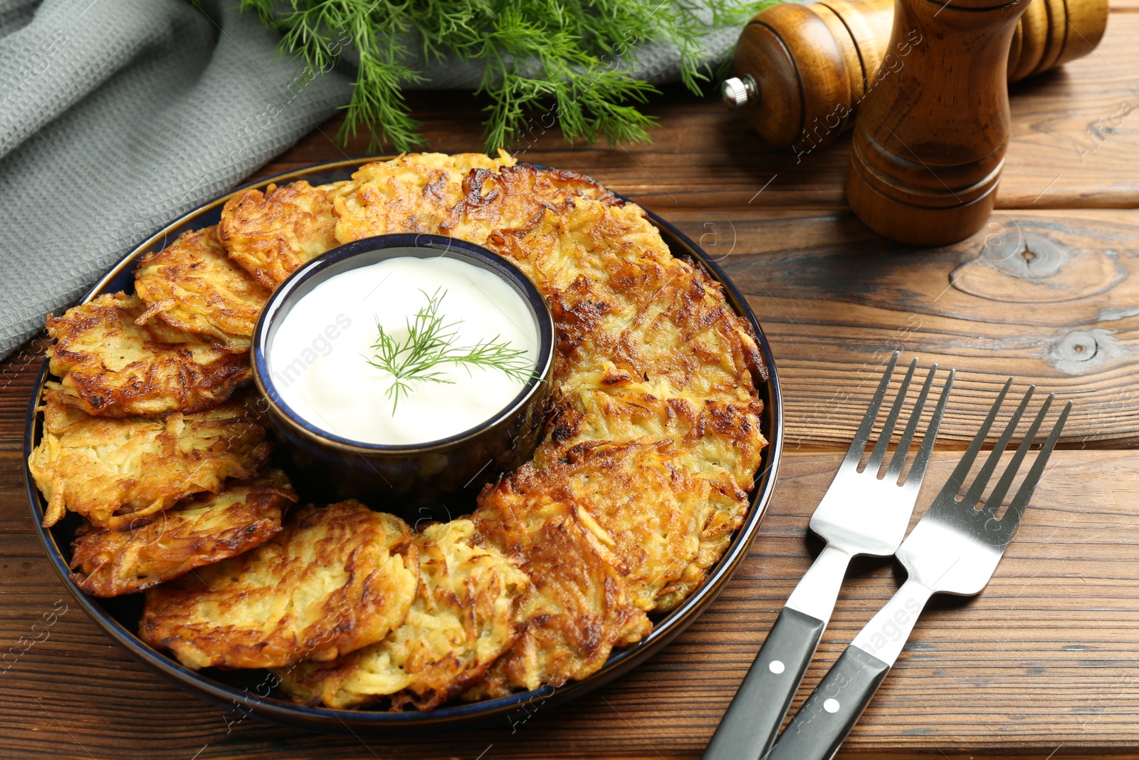 Photo of Delicious potato pancakes served on wooden table