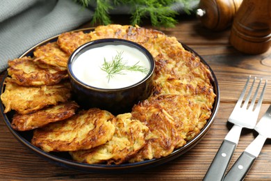 Photo of Delicious potato pancakes served on wooden table, closeup