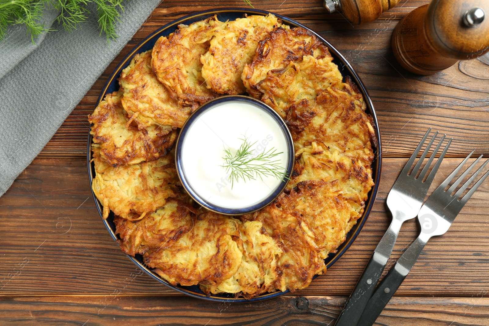 Photo of Delicious potato pancakes served on wooden table, flat lay