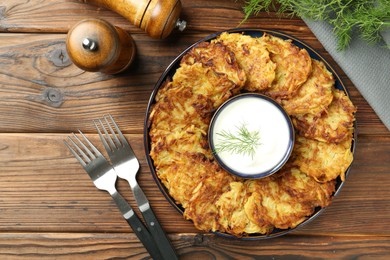 Photo of Delicious potato pancakes served on wooden table, flat lay