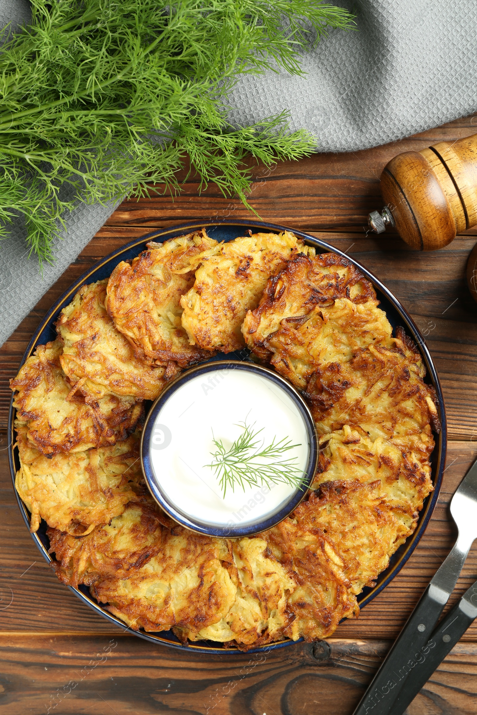 Photo of Delicious potato pancakes served on wooden table, flat lay