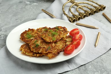 Photo of Delicious potato pancakes with fresh tomatoes and dill on grey textured table