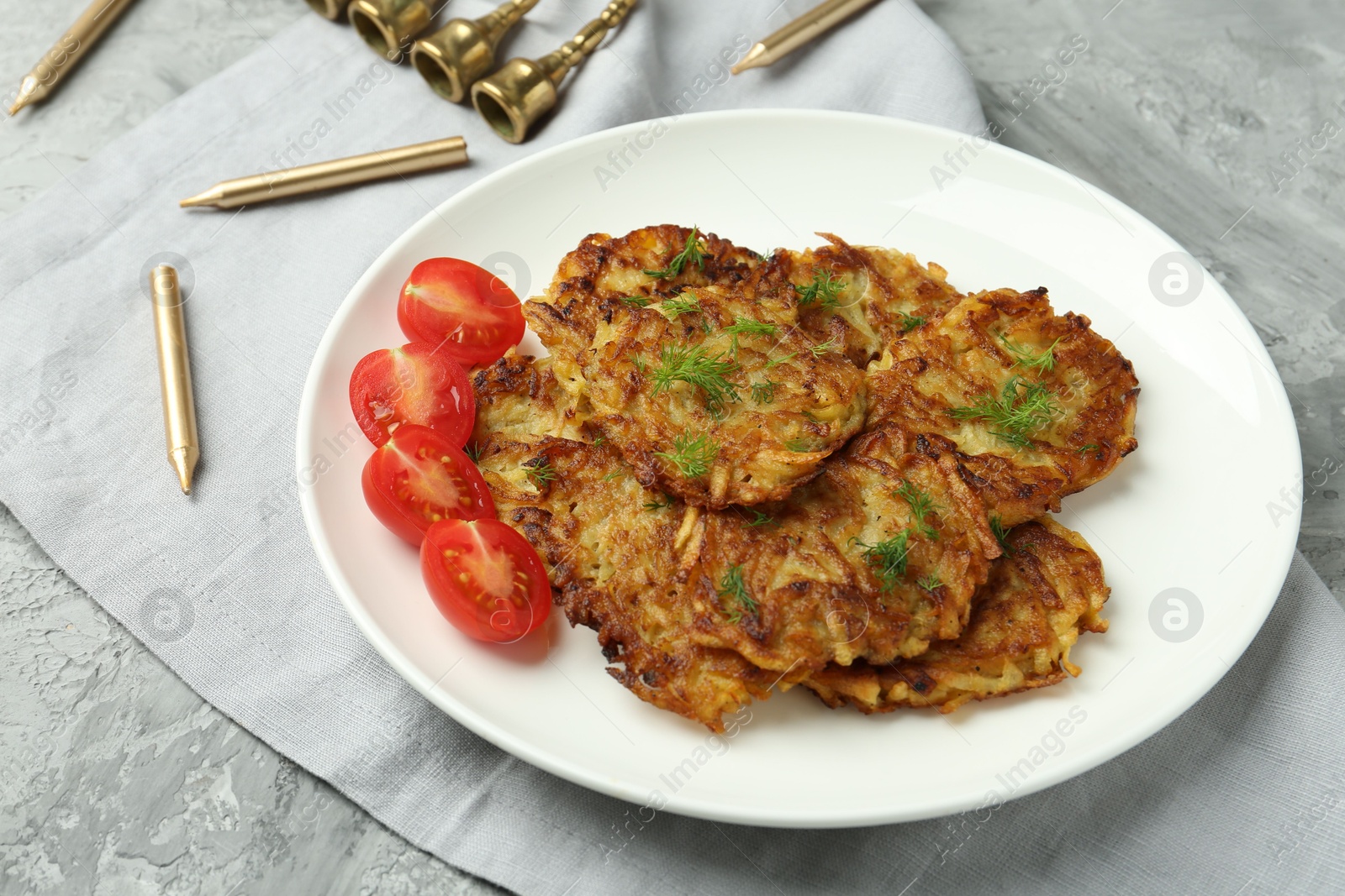 Photo of Delicious potato pancakes with fresh tomatoes and dill on grey textured table