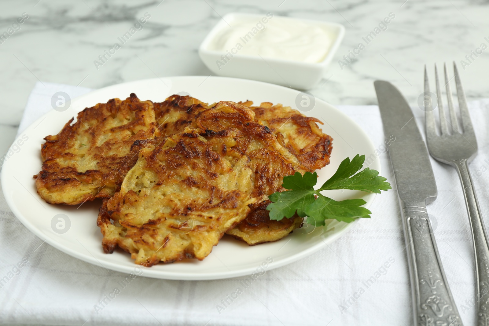 Photo of Delicious potato pancakes served on white marble table, closeup