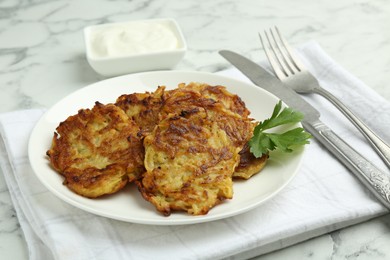 Delicious potato pancakes served on white marble table, closeup