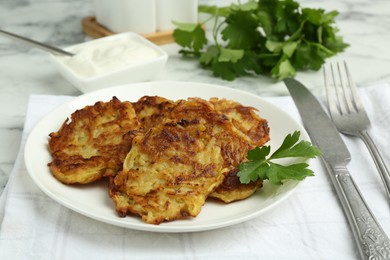 Photo of Delicious potato pancakes served on white marble table, closeup