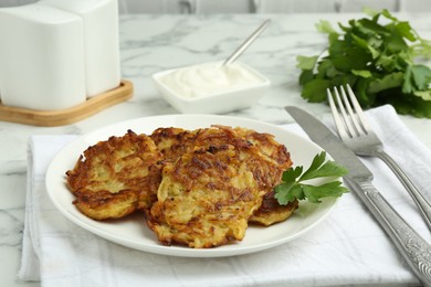 Photo of Delicious potato pancakes served on white marble table, closeup