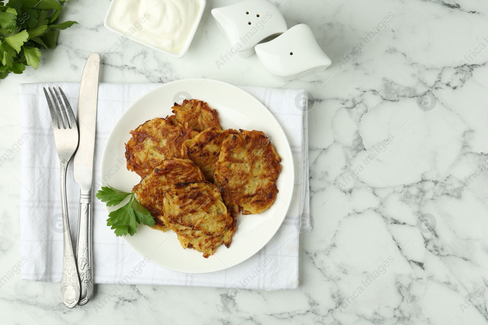 Photo of Delicious potato pancakes served on white marble table, flat lay. Space for text