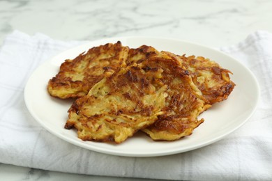 Photo of Delicious potato pancakes on white marble table, closeup