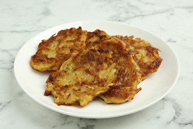 Photo of Delicious potato pancakes on white marble table, closeup