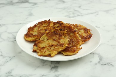 Photo of Delicious potato pancakes on white marble table, closeup