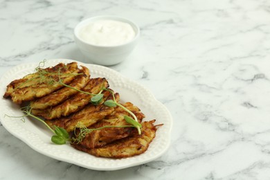 Photo of Delicious potato pancakes served on white marble table. Space for text