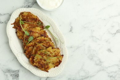 Photo of Delicious potato pancakes served on white marble table, flat lay. Space for text