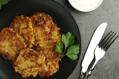 Photo of Delicious potato pancakes served on grey table, flat lay