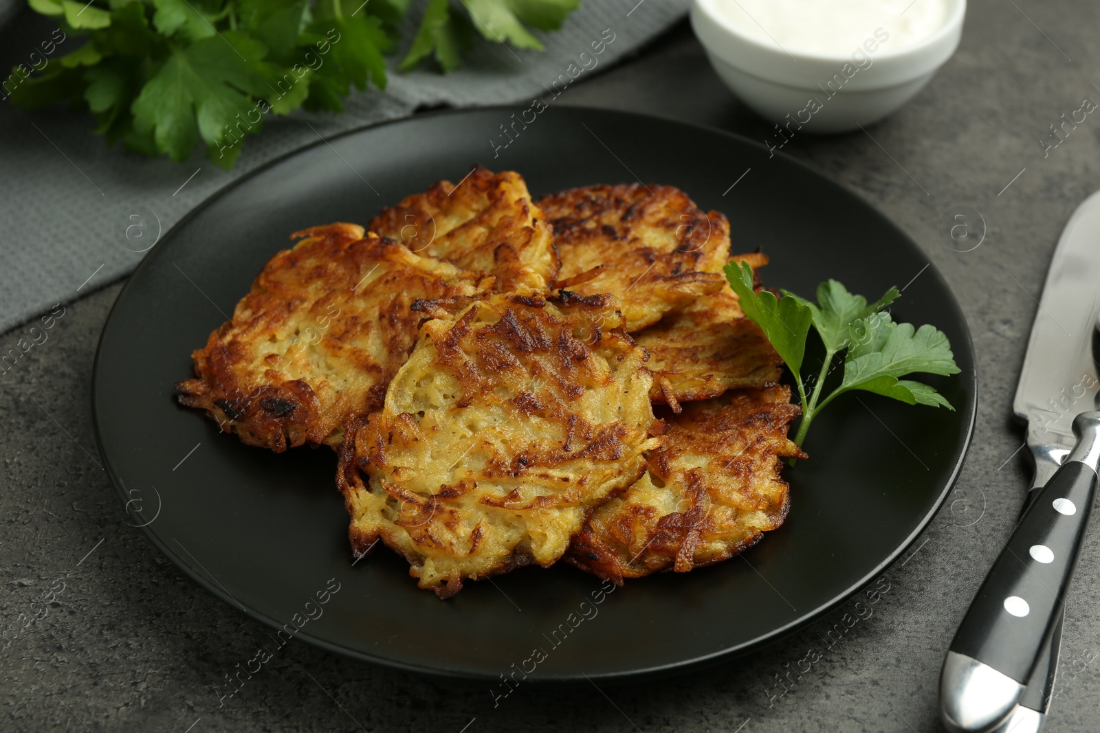 Photo of Delicious potato pancakes served on grey table, closeup