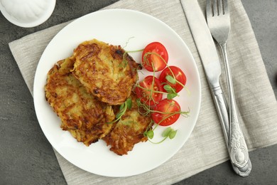 Photo of Delicious potato pancakes served on grey table, flat lay