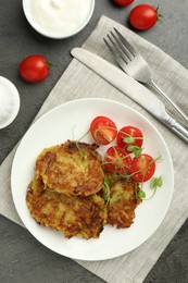 Photo of Delicious potato pancakes served on grey table, flat lay