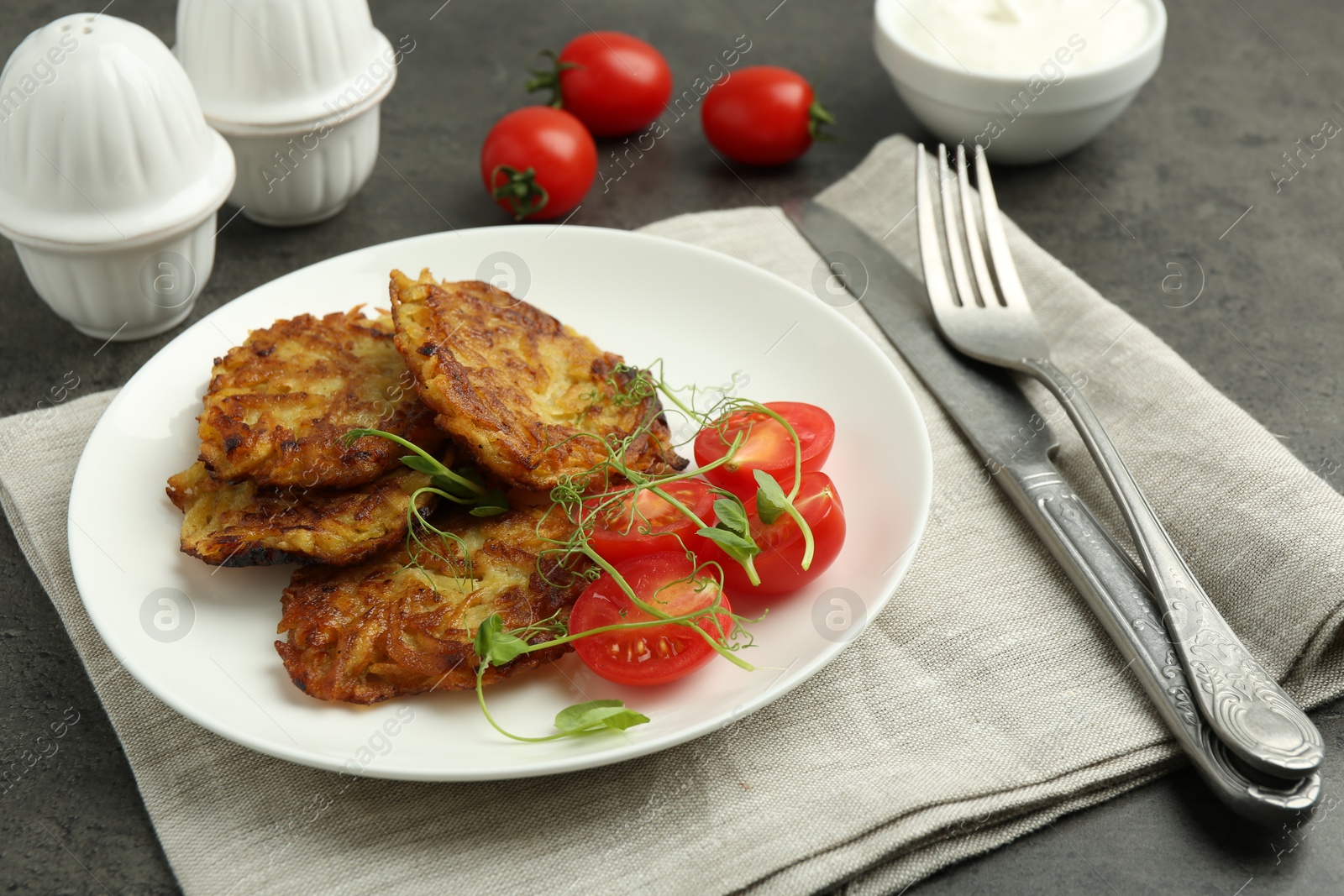 Photo of Delicious potato pancakes served on grey table