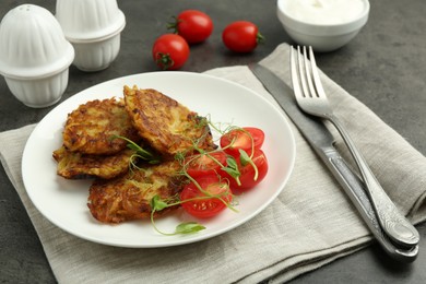 Photo of Delicious potato pancakes served on grey table