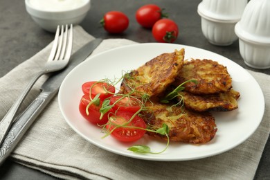 Delicious potato pancakes served on grey table, closeup