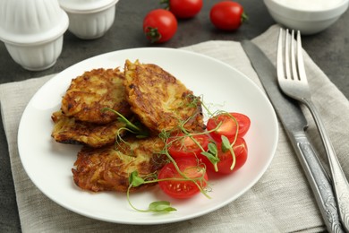 Photo of Delicious potato pancakes served on grey table, closeup