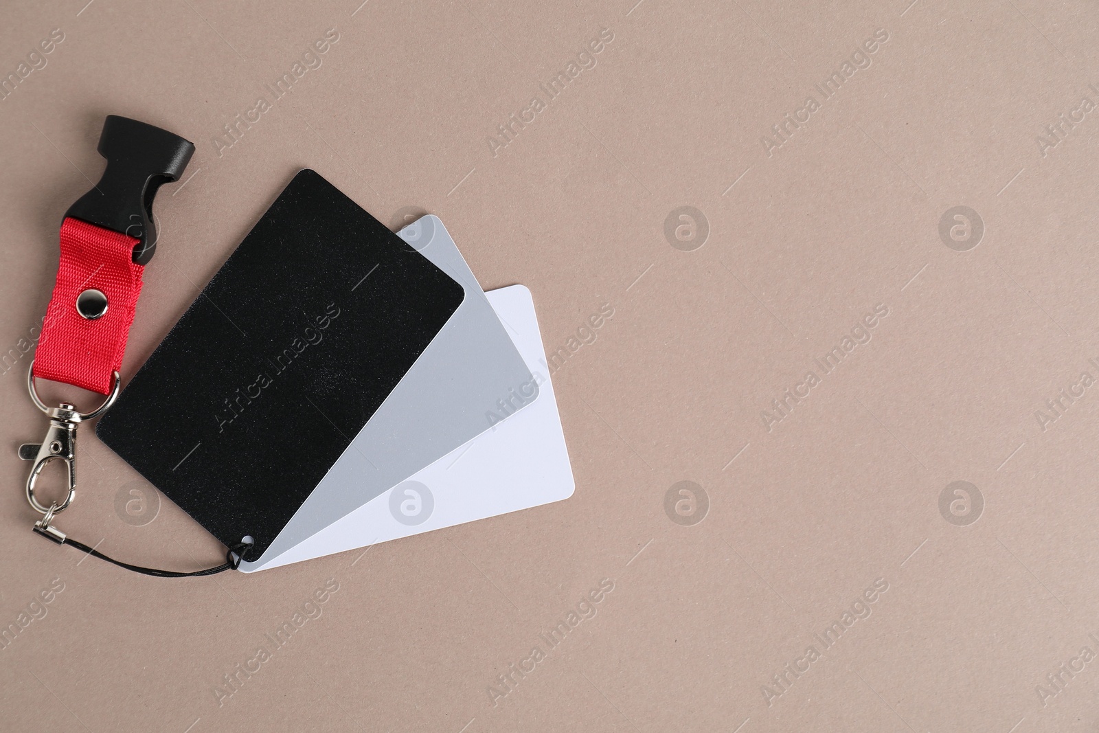 Photo of White balance calibration cards on beige background, top view. Space for text