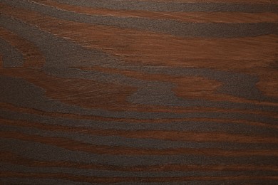 Photo of Texture of wooden surface after applying walnut wood stain as background, top view