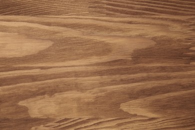 Photo of Applying walnut wood stain. Texture of wooden surface as background, top view