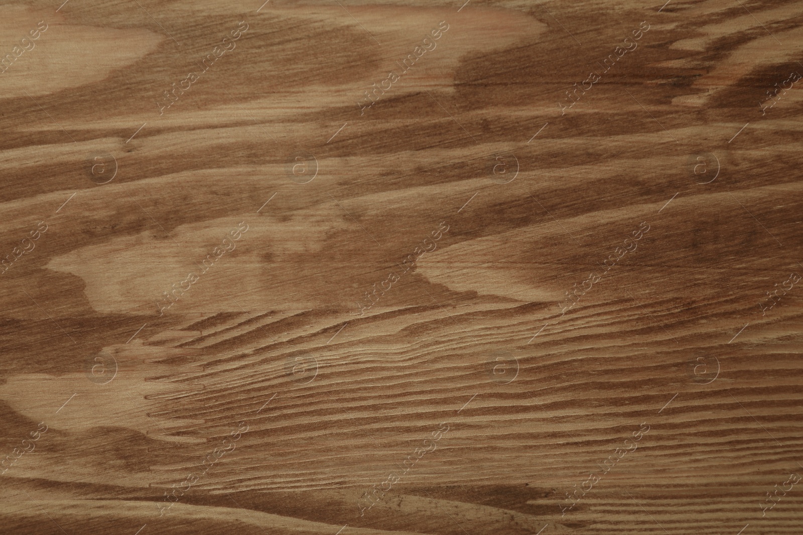 Photo of Applying walnut wood stain. Texture of wooden surface as background, top view