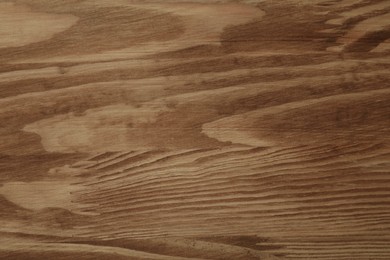 Photo of Applying walnut wood stain. Texture of wooden surface as background, top view