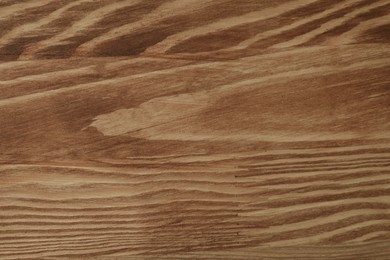 Photo of Applying walnut wood stain. Texture of wooden surface as background, top view