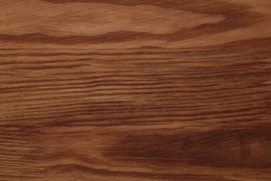 Photo of Applying walnut wood stain. Texture of wooden surface as background, top view