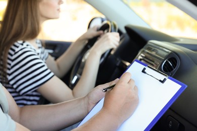 Driving school. Student passing driving test with examiner in car, closeup