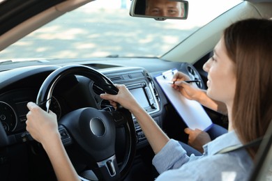 Driving school. Student passing driving test with examiner in car