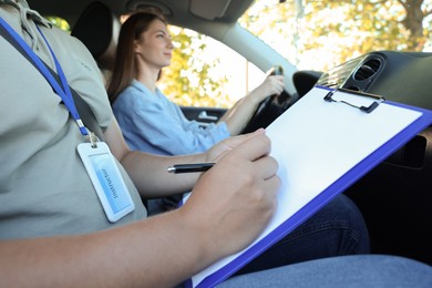 Driving school. Student passing driving test with examiner in car