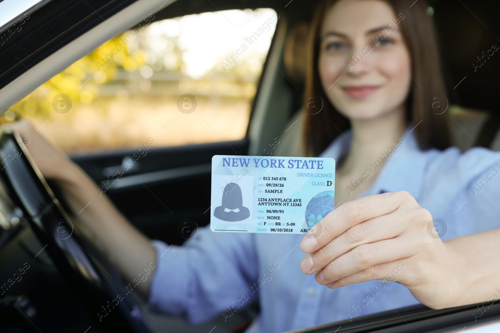 Photo of Driving school. Woman with driving license in car, selective focus