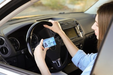 Photo of Driving school. Woman with driving license in car