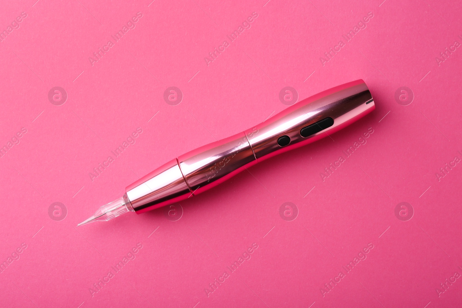 Photo of Professional permanent makeup machine on pink background, top view