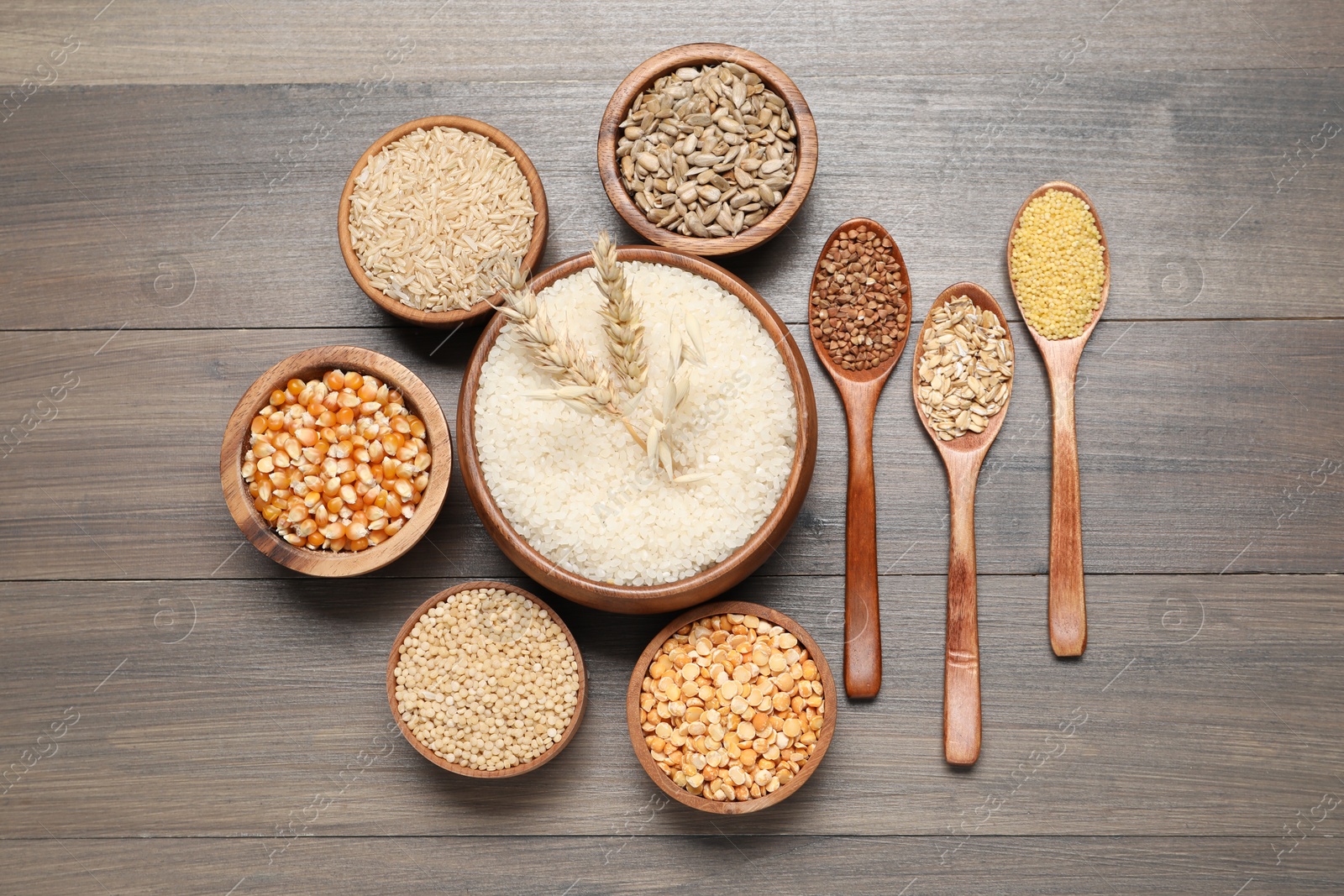 Photo of Different types of cereals and seeds on wooden table, flat lay