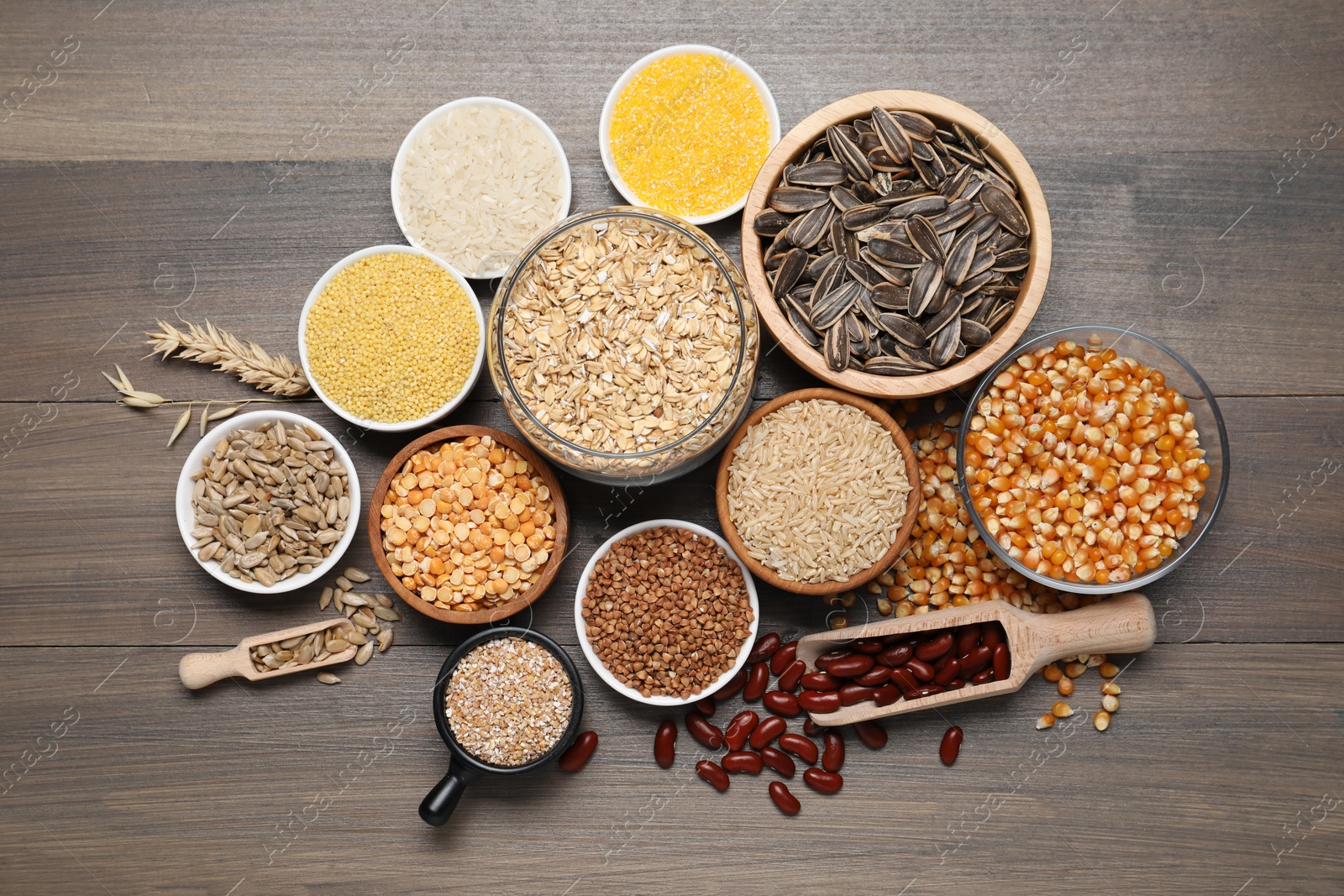 Photo of Different types of cereals, seeds and legumes on wooden table, flat lay