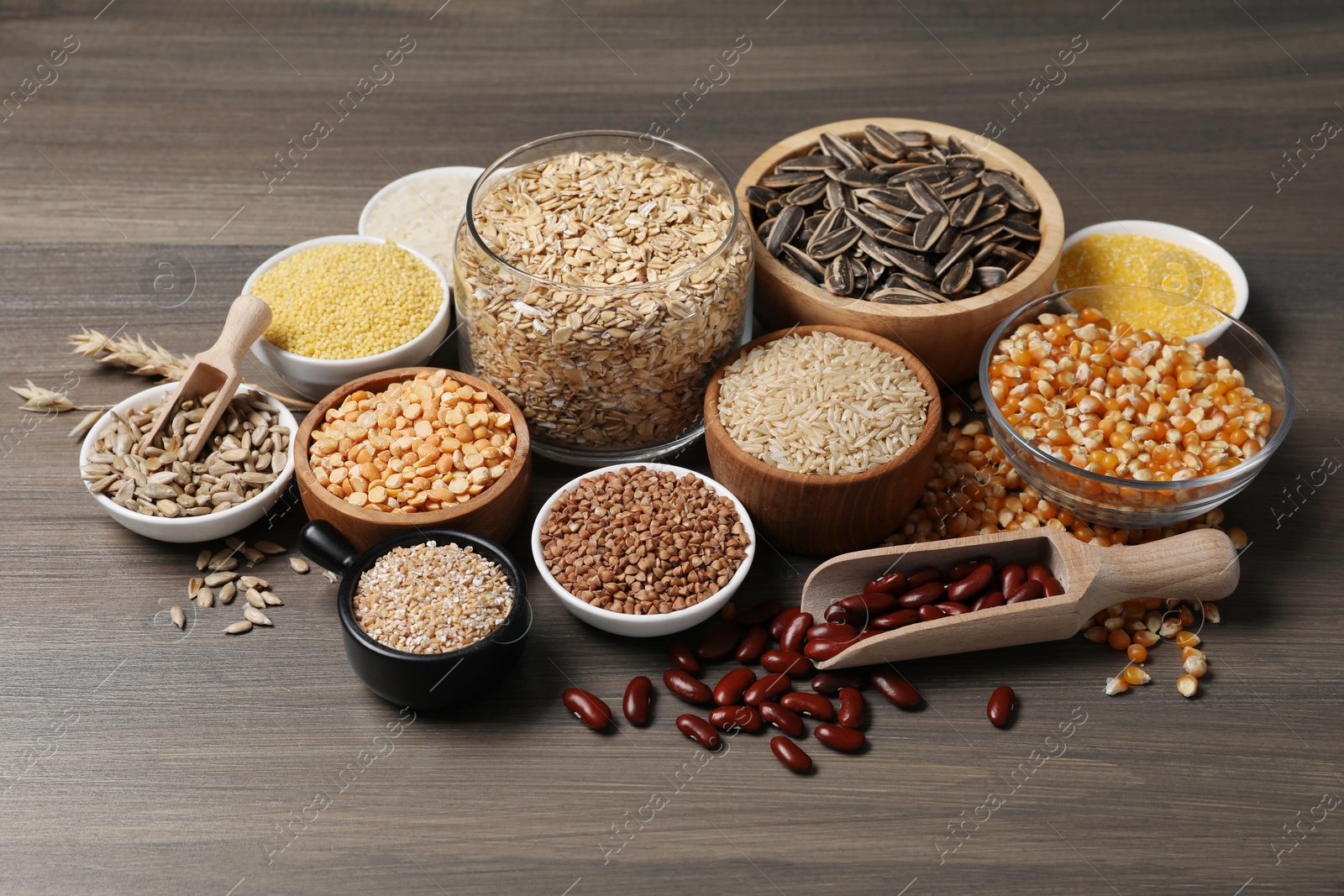 Photo of Different types of cereals, legumes and seeds on wooden table