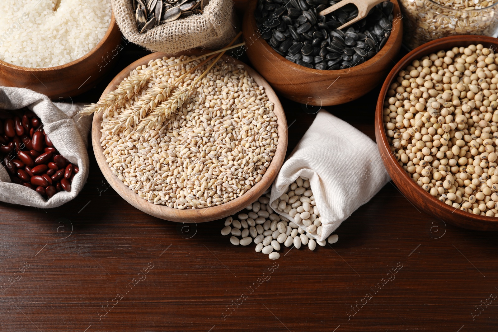 Photo of Different types of cereals, seeds and legumes on wooden table, flat lay