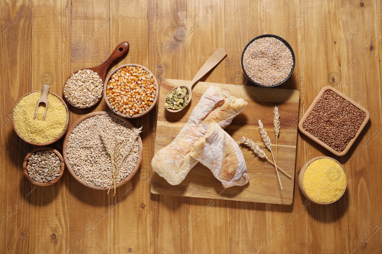 Photo of Different types of cereals and seeds on wooden table, flat lay