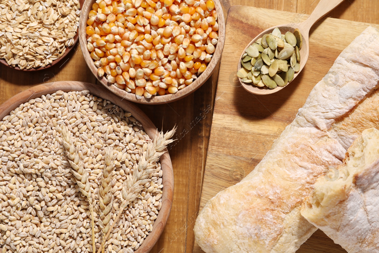 Photo of Different types of cereals and seeds on wooden table, flat lay