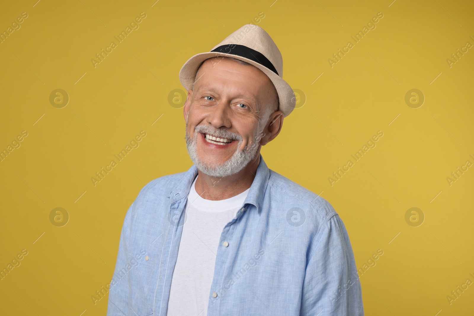 Photo of Portrait of happy senior man on yellow background